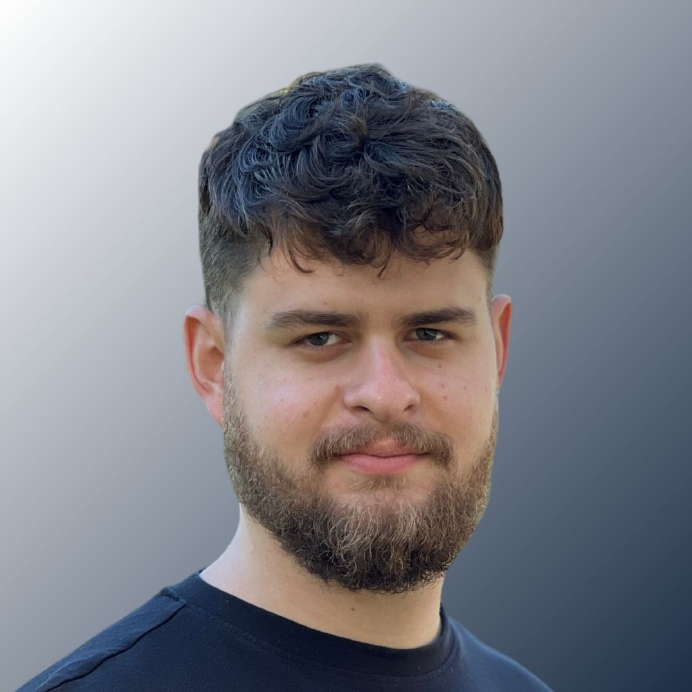 1 portrait of Philipp Schaetz with a grey wall in the background.