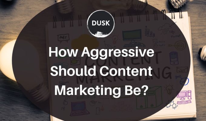 Front image of a blog titled "How aggressive should content marketing be? "with notebook written " Content marketing " as the background and the title displayed in corporate typography