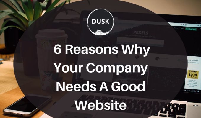 Dusk d (33) Front image of a blog titled "6 Reasons Why Your Company Needs a Good Website " with the website screen on a laptop placed on top of a wooden desk as the background and the title displayed in corporate typography